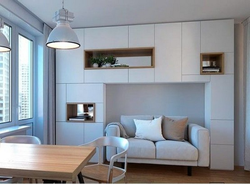 Продуманная система хранения вокруг дивана в гостиной в маленькой квартире