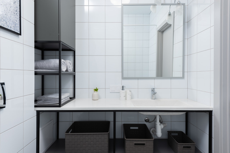 Белая квадратная плитка поможет сэкономить при ремонте ванной, а разбавить ее можно графичной мебелью и декором.